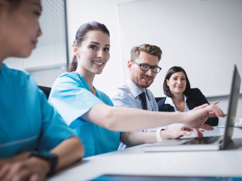 Doctors discussing over laptop in meeting at conference room